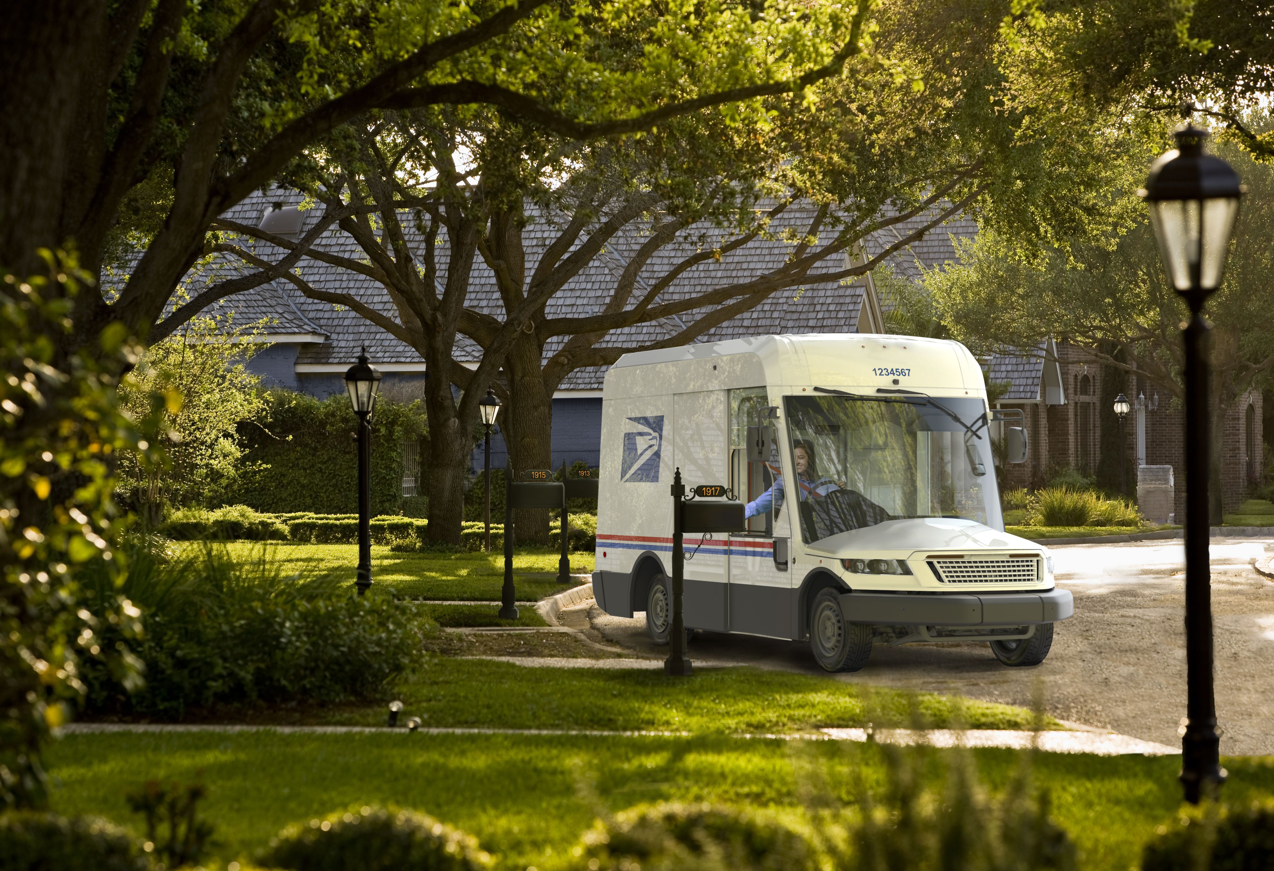 A postal carrier in an electric NGDV delivering mail
